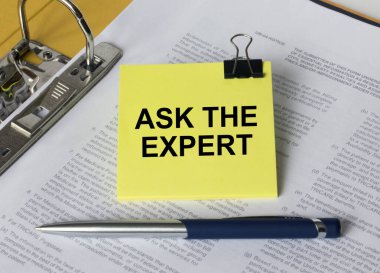 Belgeler ve mavi metal kalemle dolu bir klasörde bulunan sarı bir çıkartmayla ilgili The Expert 'a Sor. İş konsepti