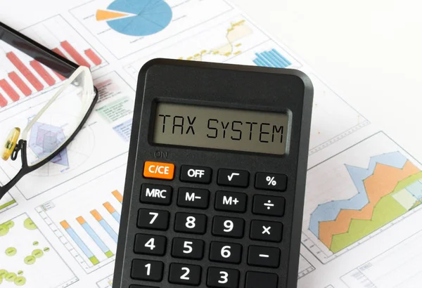 Kalkulator Tekstem Wyświetlaczu Systemu Podatkowego Jest Wykresach Finansowych Okularami Może — Zdjęcie stockowe