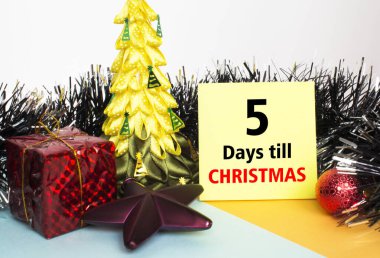 Noel ağacı oyuncaklar ve süslemelerle süslenmiş, hediye kutuları ve Noel 'e 5 gün kala mesajla yapıştırılmış sarı etiket. Tebrikler için kullanılabilir.