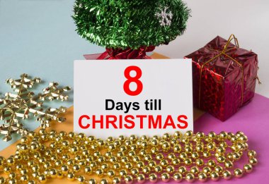Oyuncak ve süslemelerle süslenmiş Noel ağacı, hediye kutuları ve Noel 'e kadar 8 gün yazılı tebrik kartı. Tebrikler için kullanılabilir.