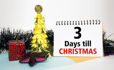 Oyuncak ve süslemelerle süslenmiş Noel ağacı, hediye kutuları ve Noel 'e 3 gün kala mesajla Notepad. Tebrikler için kullanılabilir.