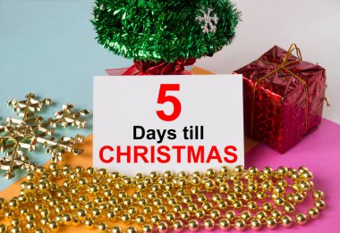 Oyuncak ve süslemelerle süslenmiş Noel ağacı, hediye kutuları ve Noel 'e kadar içinde 5 günlük mesaj olan tebrik kartı. Tebrikler için kullanılabilir.