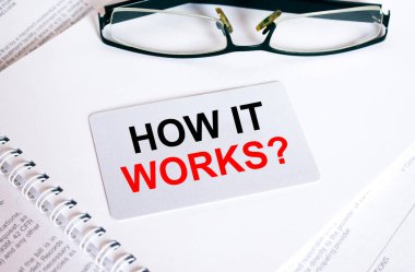 Gözlük ve metin belgeleriyle bir not defterinin üzerinde duran bir kartvizitle nasıl çalıştığını yaz. İş konsepti