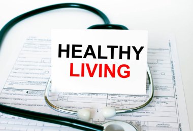 Stetoskop ve tıbbi belgelerle beyaz kartta yaşayan Sağlıklı Metin. Tıbbi konsept fotoğrafı