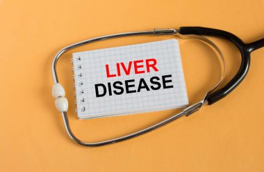 Turuncu arka planda steteskop bulunan bir not defterine karaciğer hastalığı mesajı at. Konsept fotoğraf olarak kullanılabilir