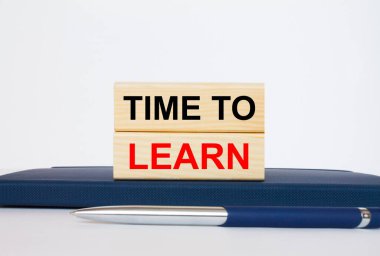 Metin Zamanı, tahta bloklarda öğrenme zamanı. Metal mavi bir kalemle bir not defterinin üzerinde yatıyor. İş konsepti fotoğrafı