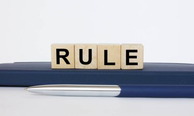 Metin kuralı, tahta küplerin üzerinde metal mavi bir kalemle bir not defterinin üzerinde yatmaktır. İş konsepti fotoğrafı