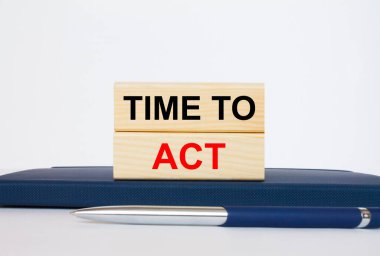 Metin zamanı ahşap bloklarda hareket etmek, metal mavi kalemle bir not defterinin üzerinde uzanmak. İş konsepti fotoğrafı