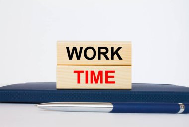 Metin Çalışma Zamanı ahşap bloklarda, metal mavi kalemle Notepad 'in üzerinde duruyor. İş konsepti fotoğrafı