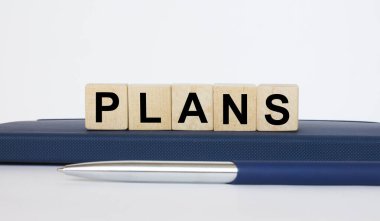 Metin, tahta küplerin üzerinde, metal mavi kalemle Notepad 'in üzerinde duruyor. İş konsepti fotoğrafı