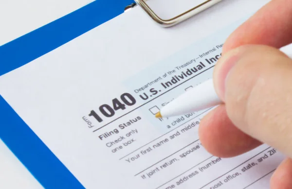 Filling out Tax Form 1040. Tax form and pen. Financial concept