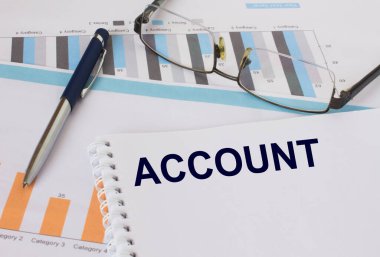 Metin hesabı olan not defteri kalem ve gözlüklerle mali tablolarda yer alıyor. Mali ve iş konsepti