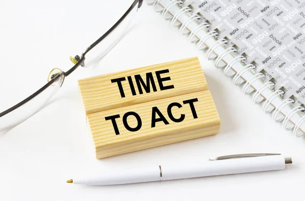 Gözlük ve kalemle not defterinin yanında duran tahta bloklarda harekete geçme zamanı. İş, mali ve pazarlama kavramları için olabilir.