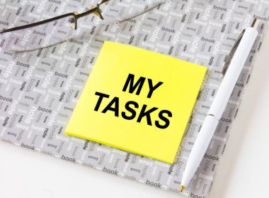 Gözlüklü ve kalemli bir not defterine sarı bir çıkartma yapıştırın. İş, mali ve pazarlama kavramları için olabilir.