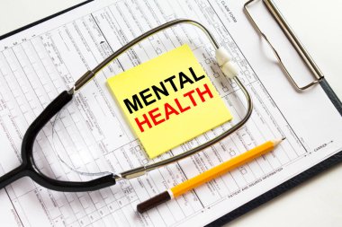 Tıbbi belgelerle dolu bir dosyanın üzerinde steteskop bulunan sarı bir çıkartma üzerinde Ruh Sağlığına Mesaj at. Konsept fotoğraf olarak kullanılabilir