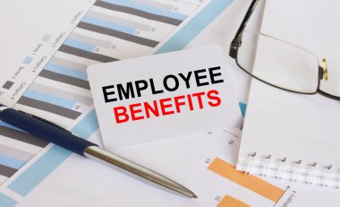 Personel Yardımları 'nın yazılı olduğu kartvizit kalem ve gözlüklerle mali tablolarda yer alıyor. Mali ve iş konsepti