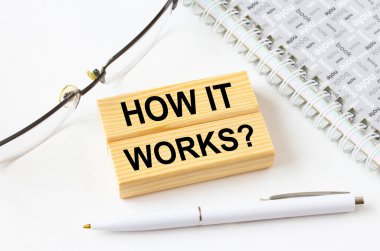 Gözlük ve kalemle not defterinin yanında duran tahta bloklarda nasıl çalıştığını yaz. İş, mali ve pazarlama kavramları için olabilir.