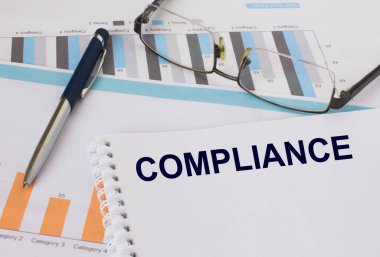 Metin Uyumlu Not Defteri, kalem ve gözlük ile finansal tablolarda yer alır. Mali ve iş konsepti