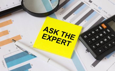 Üzerinde metin olan sarı etiket diyagramlarda hesap makinesi beyaz kalemle The Experrt 'e sorun. İş ve mali konsept