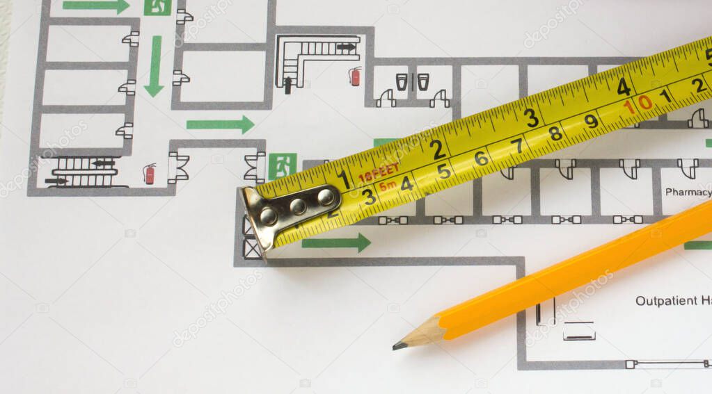 Yellow pencil, measuring tape and building plans. Concept photo
