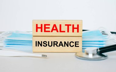 Maske, steteskop ve termometreyle birlikte yazılı odun bloklar. Tıbbi konsept