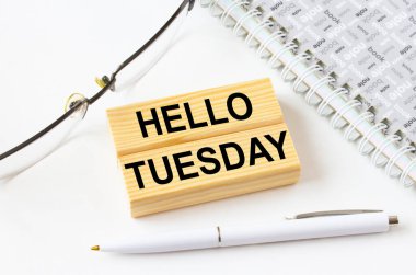 Salı günü tahta bloklarda gözlük ve kalemle not defterinin yanında duran 