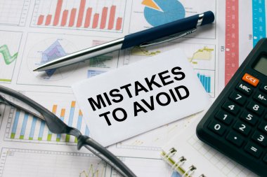 Gözlük, kalem ve hesap makinesiyle kaçınmak için yanlışlıkla yazılmış bir kartvizit. Mali konsept