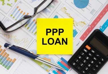 Üzerinde PPP kredisi, gözlük, kalem ve hesap makinesi olan çıkartma kartı. Mali konsept