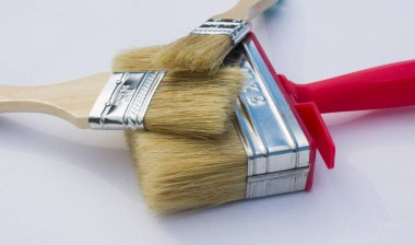 Boya fırçaları beyaz arka planda izole bir şekilde birbirlerinin üzerinde yatıyorlar. Tamir ya da inşaat konsepti olarak kullanılabilir
