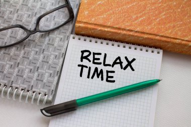 Not defteri, başka bir not defteri, kalem ve gözlük ile rahatlama zamanı. Üst görünüm