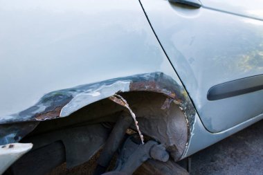 Gri bir arabada paslanmış paslı tekerlek kemerleri. Onarım hazırlığı