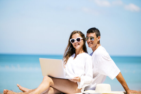 Summer couple using laptop