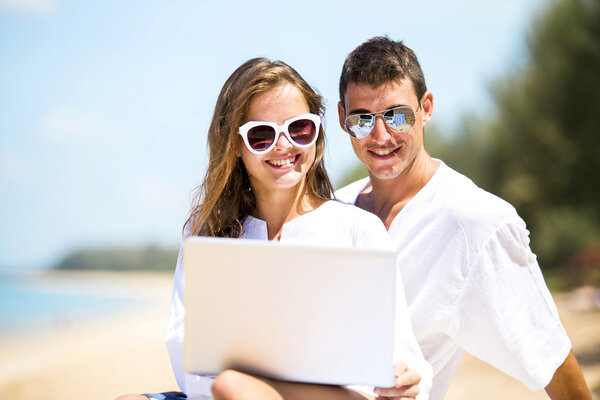 Summer couple using laptop