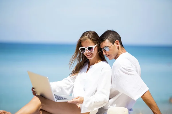 Summer couple using laptop — Stock Photo, Image