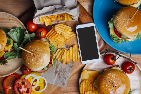 Hamburgers with moblie phone — Stock Photo, Image