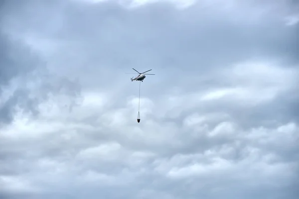 Kasvetli Bir Gökyüzünün Arka Planında Kovası Olan Itfaiye Helikopteri — Stok fotoğraf