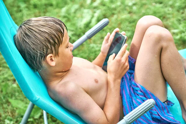 Gadget Sucht Nasser Junge Sitzt Nach Schwimmen Freibad Auf Sonnenliege — Stockfoto