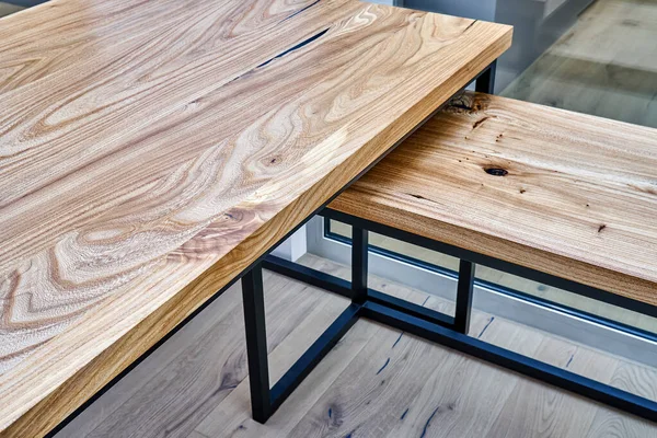 Live edge elm gaming desk countertop with metal base in a modern home office. Fragment of the desk