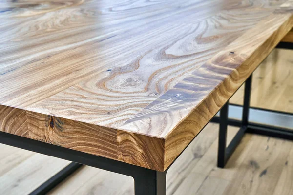 Live edge elm gaming desk countertop with metal base in a modern home office. Details close-up