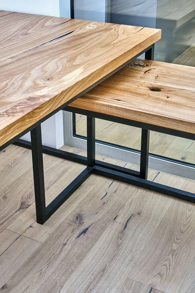 Live edge elm gaming desk countertop with metal base in a modern home office. Fragment of the desk