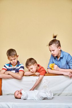 Mutlu abiler dikkatli bakın ve nazikçe dokunun. Yumuşak, beyaz vücutlu, ahşap karyolada uzanan küçük kardeş.
