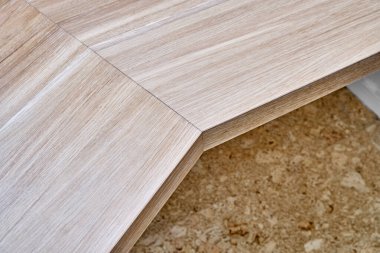 Beyaz duvara monte edilmiş bembeyaz meşe ağacından yapılmış zarif yazı masası.