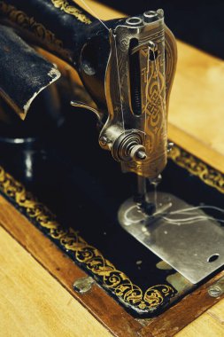 Odanın yakınındaki ahşap masada klasik el yapımı dikiş makinesi.