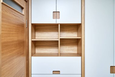 Gardırobun ayrıntıları yakın plan. Düz parmaklı modern ahşap gardırop gardırop kapıları. Açık gri dolaplı meşe kaplı kontrplak dolaplar. Modern mobilya