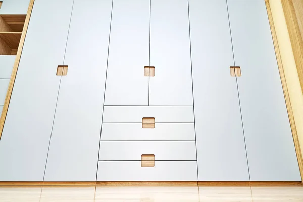 Modern wooden wardrobe with flat finger pull wardrobe doors. Oak veneered plywood cabinets with light gray painted cabinet doors. Modern furniture