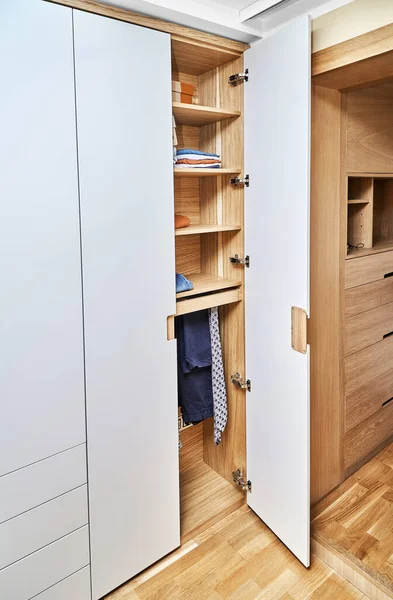 Gardırobun ayrıntıları yakın plan. Düz parmaklı ahşap gardırop gardırop kapıları. Açık gri dolaplı meşe kaplı kontrplak dolaplar. Modern mobilya