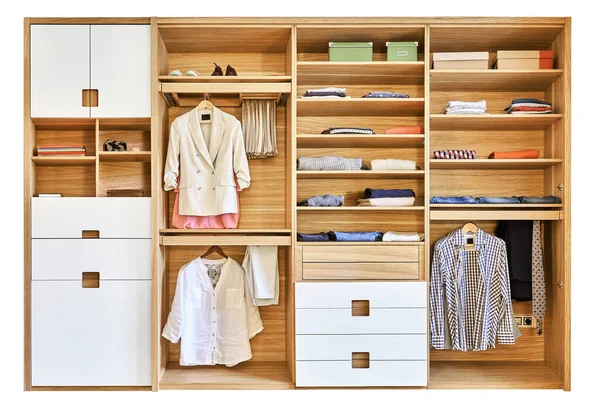 Internal details of the wooden wardrobe with slide out rack for coathangers. Modern wardrobe with clothes hanging on slide out racks and folded on the shelves. Modern furniture