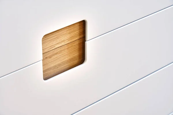 Detail of the wardrobe close-up. Modern wooden wardrobe with flat finger pull wardrobe doors. Oak veneered plywood cabinets with light gray painted cabinet doors. Modern furniture