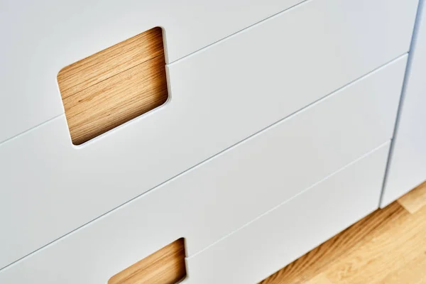 Detail of the wardrobe close-up. Modern wooden wardrobe with flat finger pull wardrobe doors. Oak veneered plywood cabinets with light gray painted cabinet doors. Modern furniture