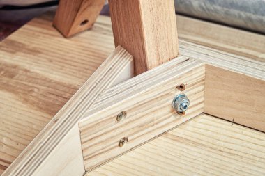 Modern marangozluk atölyesinde baş aşağı duran yeni bir kontrplak masası, kaplama ve katı ışık külünün köşesi.